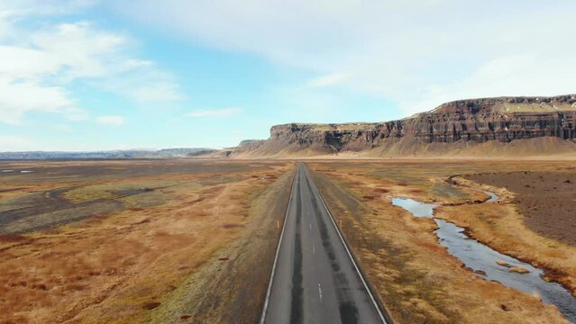 Aerial fly over Icelandic southern ring road with no cars and scenic mountains and wild landscape. Iceland road trip concept
