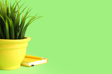 Artificial grass with notebook on green background