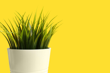 Artificial grass on yellow background, closeup
