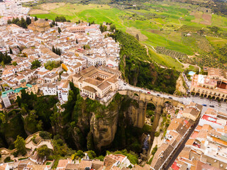 Aerial view of rocky landscape of Ronda with buildings and Bridge, Andalusia, Spain