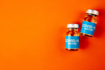 top view antivirus vaccines in little cans on orange background lab disease color virus covid-...