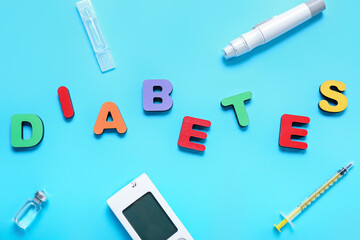 Word DIABETES with insulin and glucometer on blue background