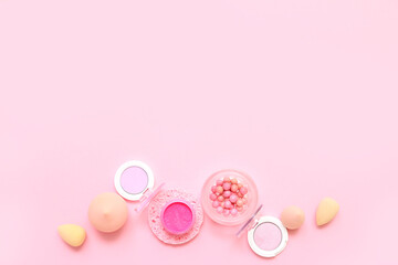 Decorative cosmetics with makeup sponges on pink background