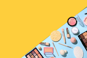 Decorative cosmetics with makeup brushes and sponges on color background