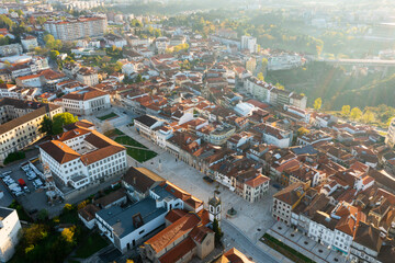 Obraz premium Scenic drone view of Portuguese city of Vila Real overlooking central square and buildings with brownish tiled roofs on sunny spring day..