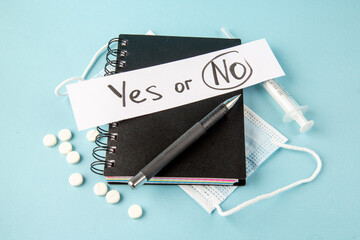 top view black copybook with pills injection and yes or no note on blue background color notepad school lesson study student college