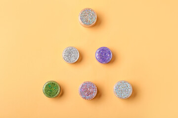 Jars of glitter on yellow background