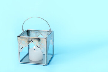 Muslim lamp with burning candle on blue background