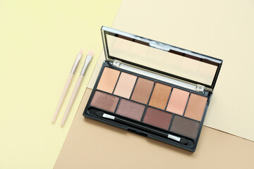 Eyeshadows with brushes on color background