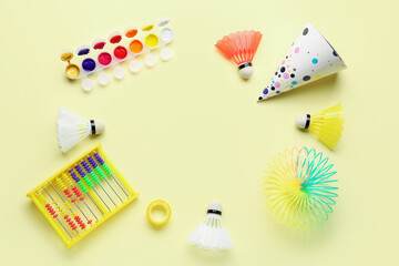 Frame made of toys with party hat on yellow background. Children's Day celebration