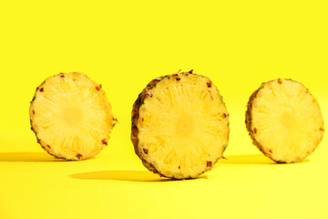 Slices of fresh ripe pineapple on yellow background