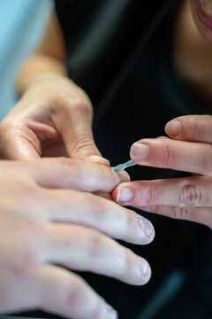 manucure d'un esth&eacute;ticienne sur la main d'un homme