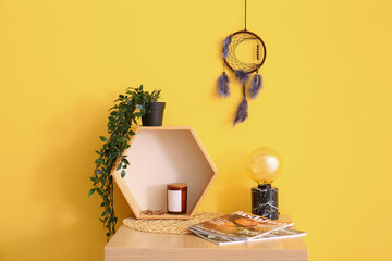 Dream catcher hanging on yellow wall in room