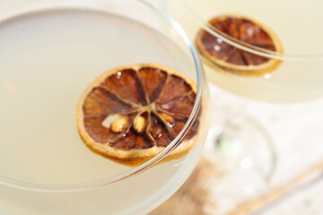 Glasses of tasty martini and dry lemon on white wooden table
