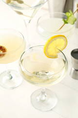 Glasses of tasty martini and lemon on light wooden table
