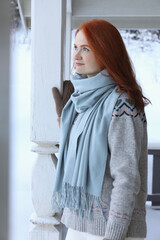 Beautiful young woman in wooden gazebo on snowy day outdoors. Winter vacation