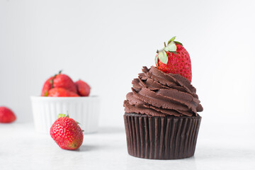 Chocolate cupcake with dark chocolate buttercream and strawberries, double chocolate cupcakes with american buttercream, tall swirl frosting on a cupcake with a strawberry