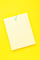 Paper sheet with clip on yellow background