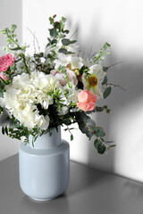 Bouquet with beautiful flowers on light gray table indoors