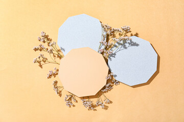 Decorative plaster podiums with gypsophila flowers on beige background