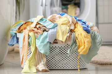 Basket with dirty clothes on floor in laundry room