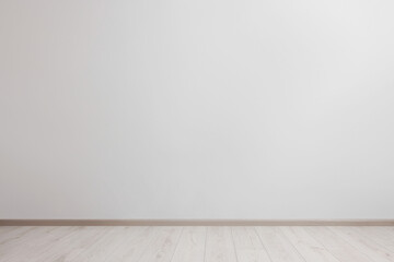 Empty room with white wall and wooden floor