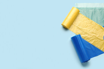 Different rolls of garbage bags on blue background