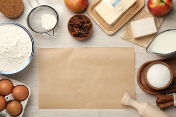 Flat lay composition with piece of empty parchment paper and different ingredients on wooden table. Yeast pastry