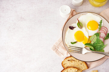 Plate with tasty fried egg, radish and spinach on light background