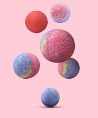 Many different bath bombs falling on pink background