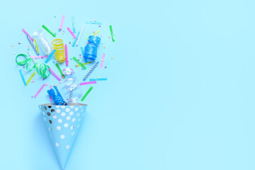 Party cone with confetti and serpentine on blue background. Children's Day celebration
