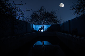 Abandoned swimming pool at night. An old swimming pool in garden.