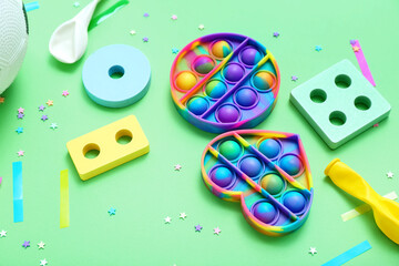 Baby toys with confetti on green background. Children's Day celebration