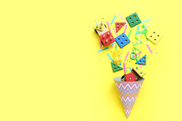 Party cone with baby blocks and confetti on yellow background. Children's Day celebration