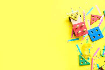 Obraz premium Baby blocks with confetti on yellow background. Children's Day celebration
