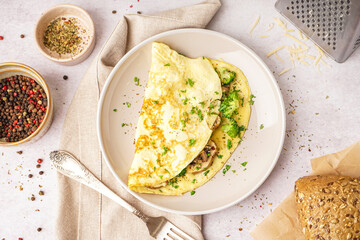 Tasty omelet with broccoli and mushrooms on light table