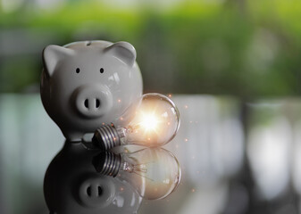 Creative idea for save or investment. piggy bank on desk with light bulb icon planning money finance. Copy space for text. saving energy economy and money concept. 