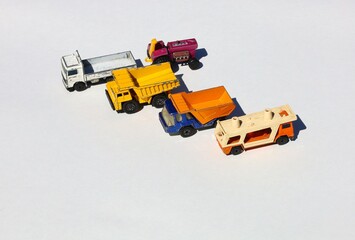 Obraz premium Four Miniature, Heavy- Duty Trucks and a Tractor