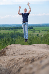 A man surrounded by mountains and forests. A man in a jump