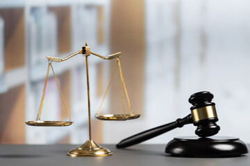 Shiny golden balanced scale and wooden gavel in court library background as symbol of justice and...