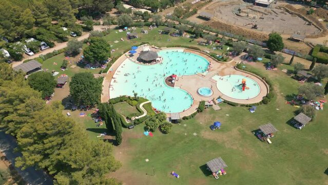 Aerial view people playing and having fun at outdoor swimming pool