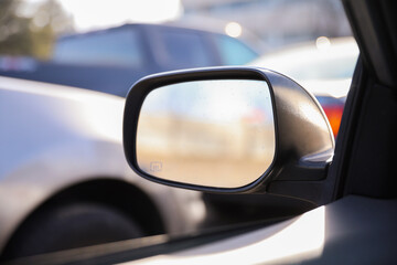 Car mirror in a stock photo symbolizes reflection, perspective, and awareness. It represents the importance of looking back, being mindful of surroundings, and gaining insights from past experiences 