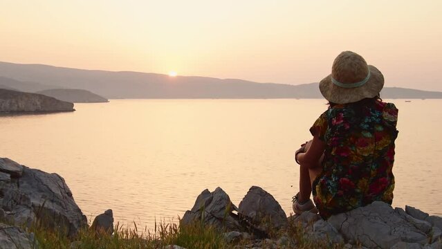 Tourist woman sit enjoy sunset panorama on viewpoint in persian gulf island