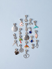 A variety of metal charms for a child's necklace or bracelet. Many charms isolated on a white...