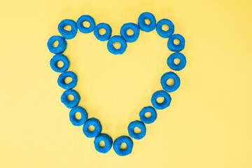 Blue cereal heart with a yellow background, commemorating autism, inclusion and love