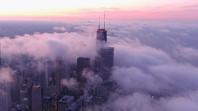 A chicago skyline consist of misty clouds. Foggy, white, beautiful, view of John Hancock tower and the city of Chicago. Sunset of chicago.
