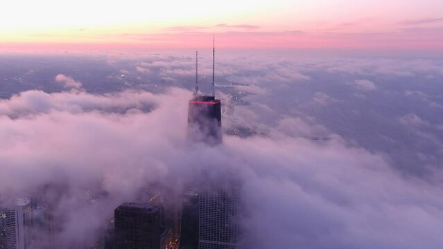 A chicago skyline consist of misty clouds. Foggy, white, beautiful, view of John Hancock tower and the city of Chicago. Sunset of chicago.