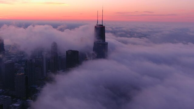 A chicago skyline consist of misty clouds. Foggy, white, beautiful, view of John Hancock tower and the city of Chicago. Sunset of chicago.