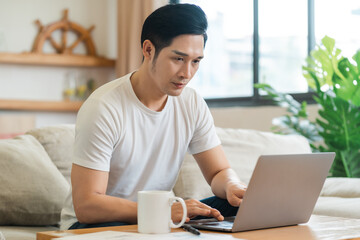 portrait of asian man sitting on sofa at home