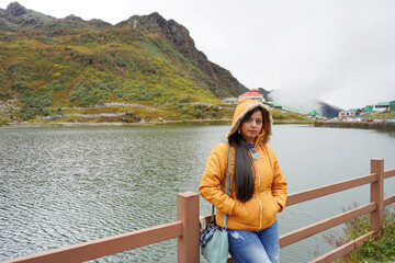 Fototapeta na wymiar Young age Tourist Girl Standing beside Tsomgo or Changu Lake at East Sikkim During Silk Route Tour